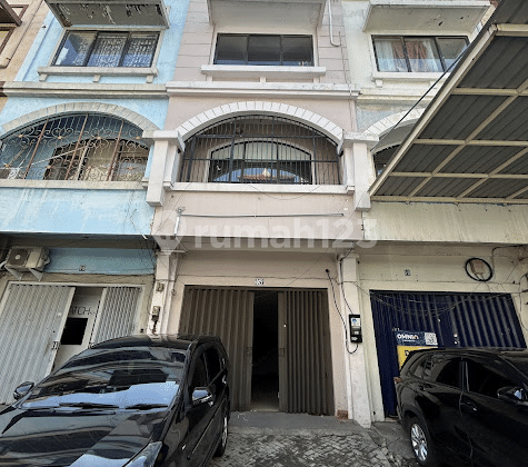 Indonesian property text means:
"For Rent: 3-Storey Shophouse, In the Panji Makmur Shophouse Complex, East Surabaya" 1