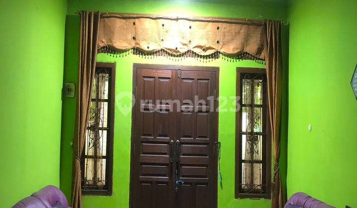 ruang tamu rumah luas di perumahan taman
