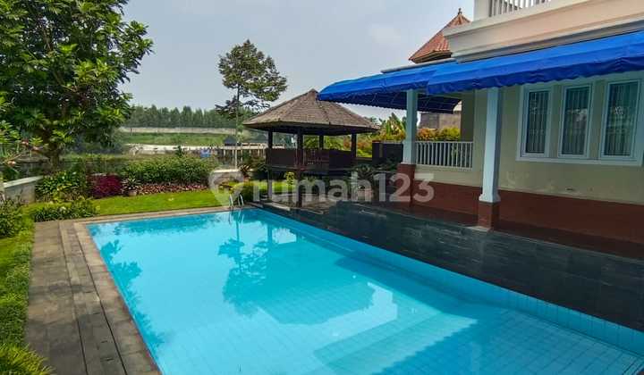 For Sale: Serasa Villa Lux - Beautiful, Spacious, Well-Maintained, Ready to Live In, Fully Furnished. Located by the lake with private lake access. Features a large swimming pool. Situated in Tatar Pitaloka, Kota Baru Parahyangan. 2