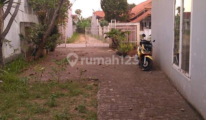 A charming one-story house ready for occupancy with a large vacant land area.